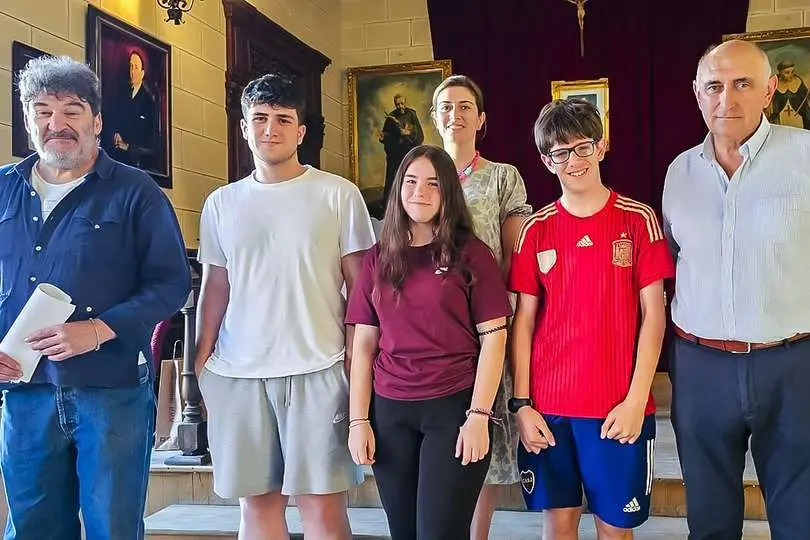 En el centro tres estudiantes que reciben la beca, tras el sorteo de ayer tarde