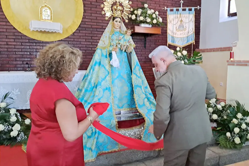 Momento en el que el general y su esposa imponen el faj&iacute;n militar a la patrona