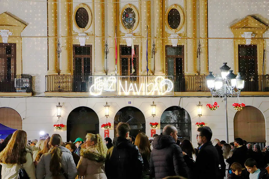 Al fondo, la fachada consistorial con los mejores deseos para estas fechas