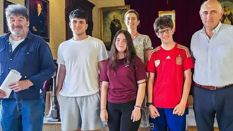 En el centro tres estudiantes que reciben la beca, tras el sorteo de ayer tarde