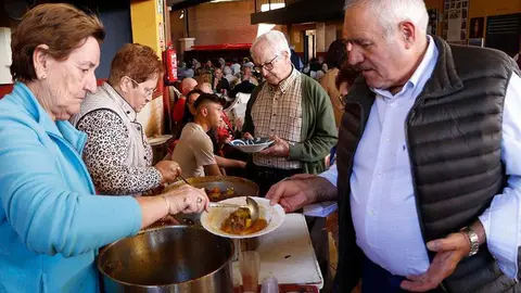 Algunos de los comensales, recogiendo la comida