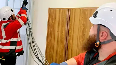 Operarios instaladores, extendiendo el nuevo cableado en el interior del edificio consistorial