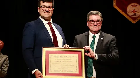 El pregonero, a la derecha, recibiendo el detalle conmemorativo de su intervenci&oacute;n de manos del presidente de la Junta de Hermandades de Semana Santa