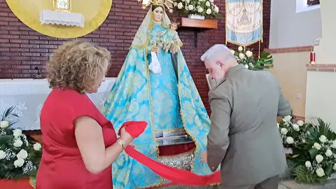 Momento en el que el general y su esposa imponen el faj&iacute;n militar a la patrona