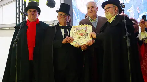 Los tres integrantes de Los Chambras, portando el Mascar&oacute;n 2026 de manos del alcalde