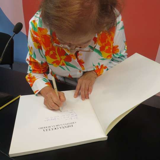 La fotografa puertollanense Cristina Garcia Rodero firmando un ejemplar de su obra España Oculta