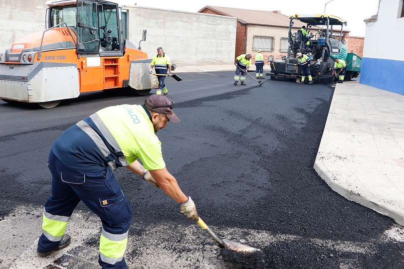 En primer término, un operario en el límete del tramo asfaltado