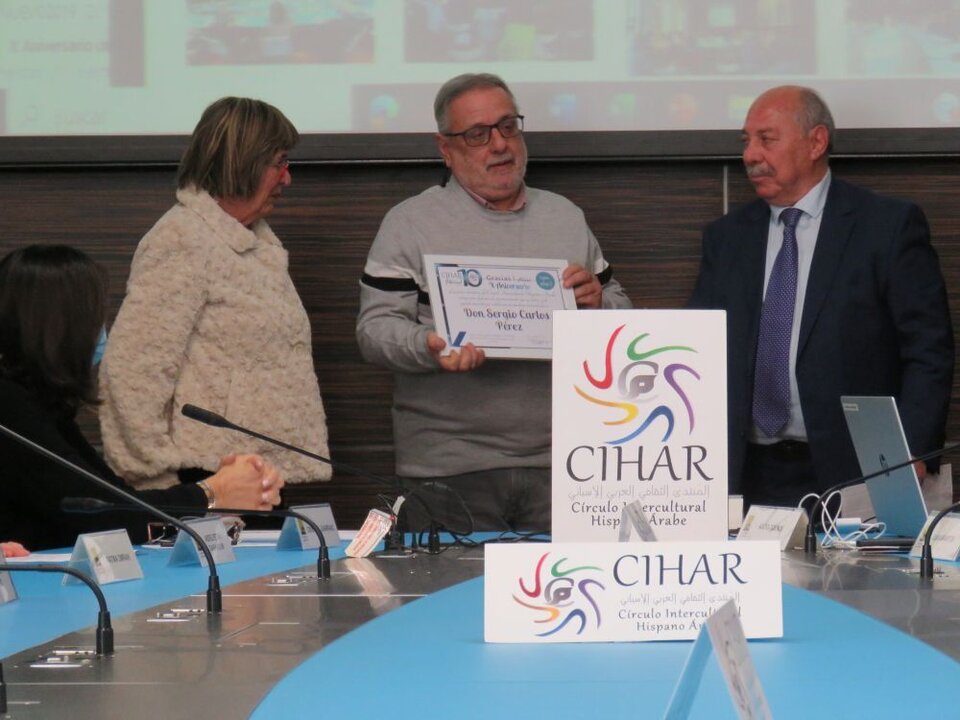 Sergio Carlos Pérez, presidente de Asociación Uruguay Córdoba, coordinador del Festival Grito de Mujer gestor intercultural, con el diploma entregado por la miembro de la junta directiva de CIHAR Victoria Porras, junto a Abdo Tounsi, presidente de CIHAH