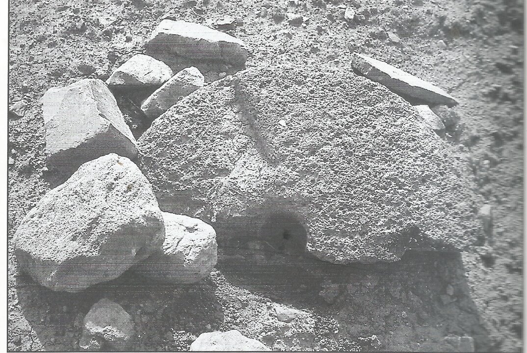 Molino de mano fragmentado y piedras de construcción