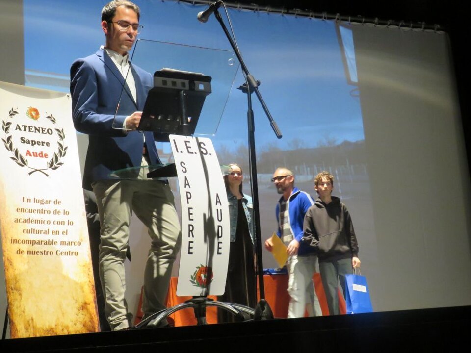 Ramiro Martín instó a subir a la alumna Inés Sorribas Gallardo, que recibía el premio Literarios Atrevimientos 2025 por su relato “El punto y coma que cambió de punto para estar a punto”. Le entregaron el premio el profesor David Llorente Oller y el alumno Juan Bachiller de Ávila
