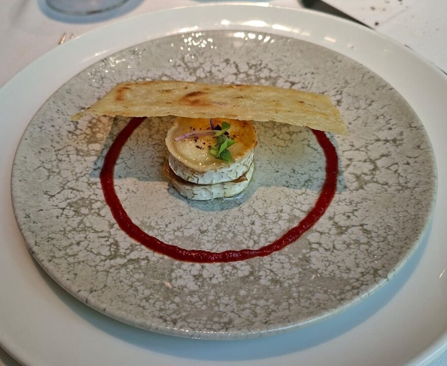 Rulo de queso de cabra con cebolla caramelizada, pan carasau y confitura de tomate