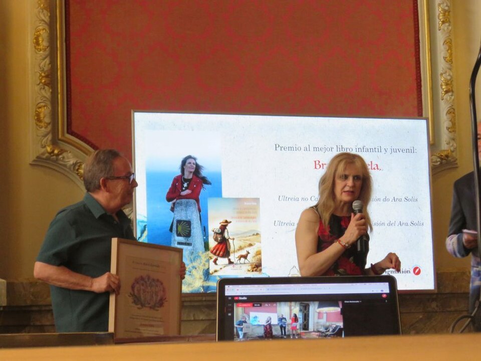 Branca Vilela , Premio al mejor libro infantil y juvenil:, por Ultreia no Camiño Inglés a misión do Ara Solis / Ultreia en el Camino Inglés: la misión del Ara Solis, entregado por Jesús Benítez Benítez, escritor y poeta