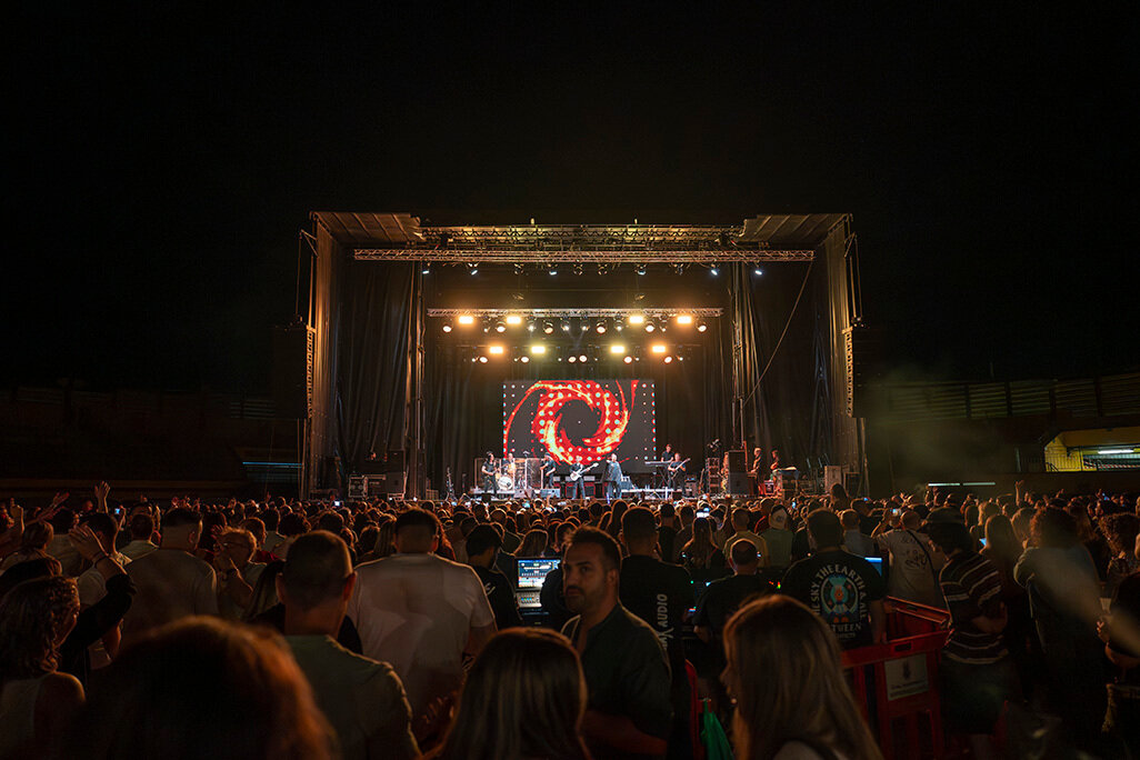 Panorámica de asistentes con el escenario al fondo durante el concierto