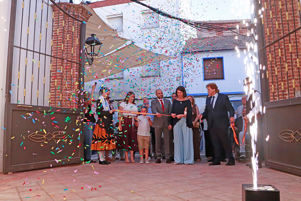 Momento en que la presidenta de la Hermandad de la Virgen del Socorro, Isabel Fernández, corta la cinta inaugural junto a autoridades e invitados