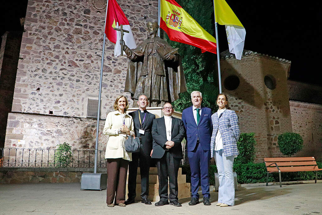 Posado ante la escultura monumental al santo almodovareño y doctor de la Iglesia, que estos días han engalanado las banderas vaticana, española y castellano-manchega