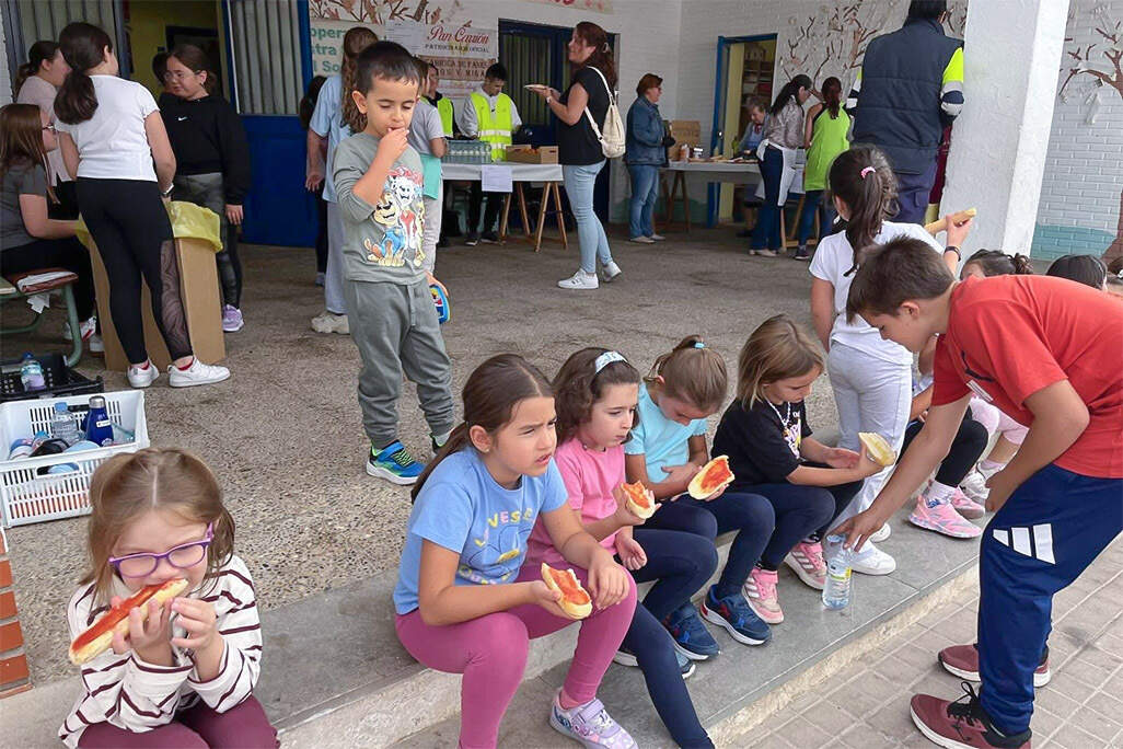 Escolares de distintos niveles, tomando tostadas con aceite y tomate