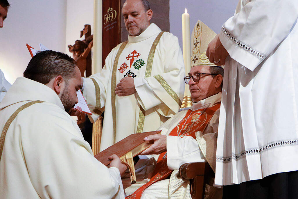 Recibiendo de manos del obispo prior un ejemplar de los Evangelios