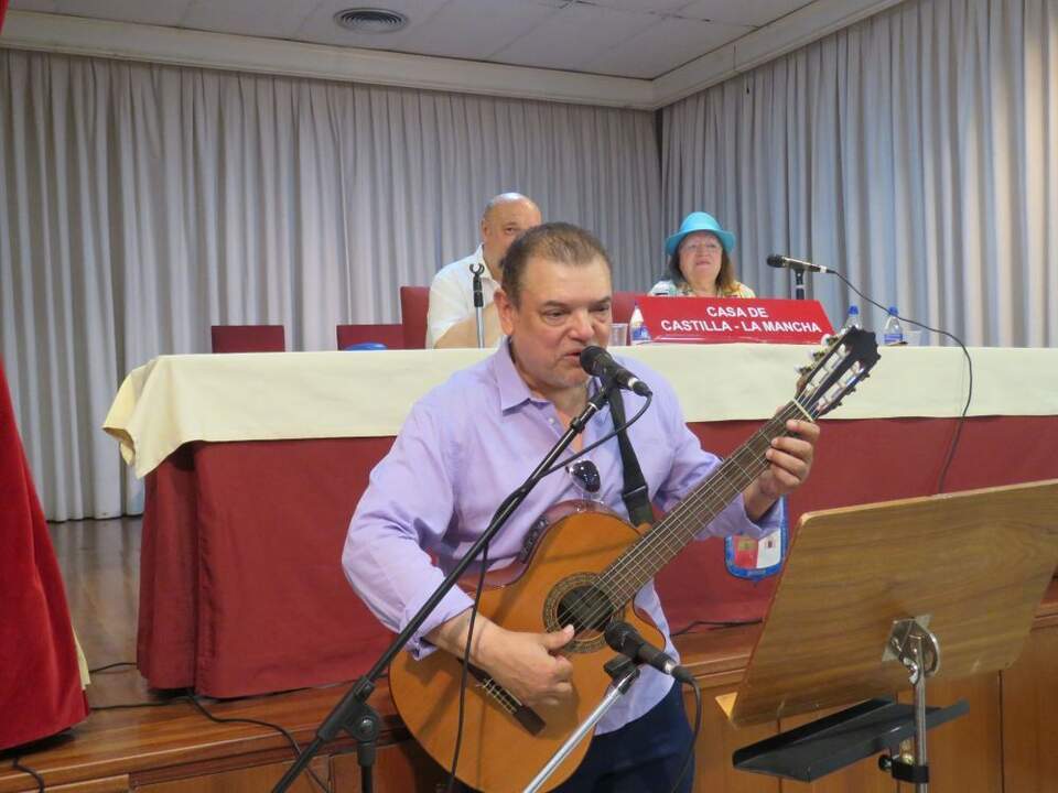 En primer término, Álex Flórez Sierra, músico, cantante y escritor colombiano, durante su actuación