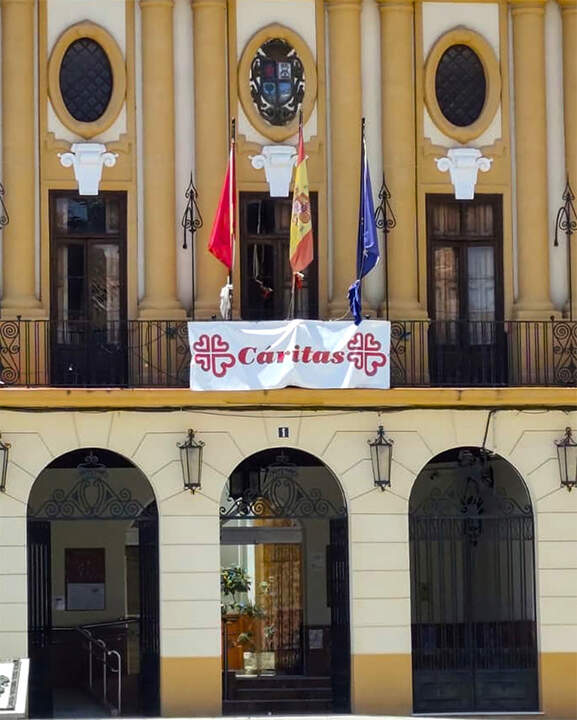 Pancarta de Cáritas en la balconada consistorial