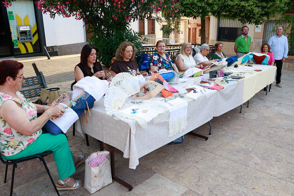 Mesa habilitada con trabajos y muestra de la labor del encaje de bolillos